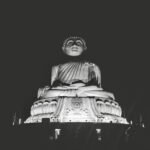 Grayscale image of the majestic Big Buddha statue illuminated at night in Phuket, Thailand.