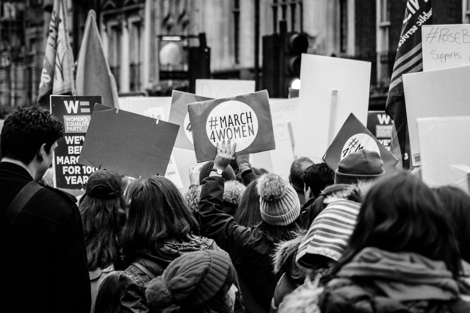 grayscale photo of group of people performing rally on street