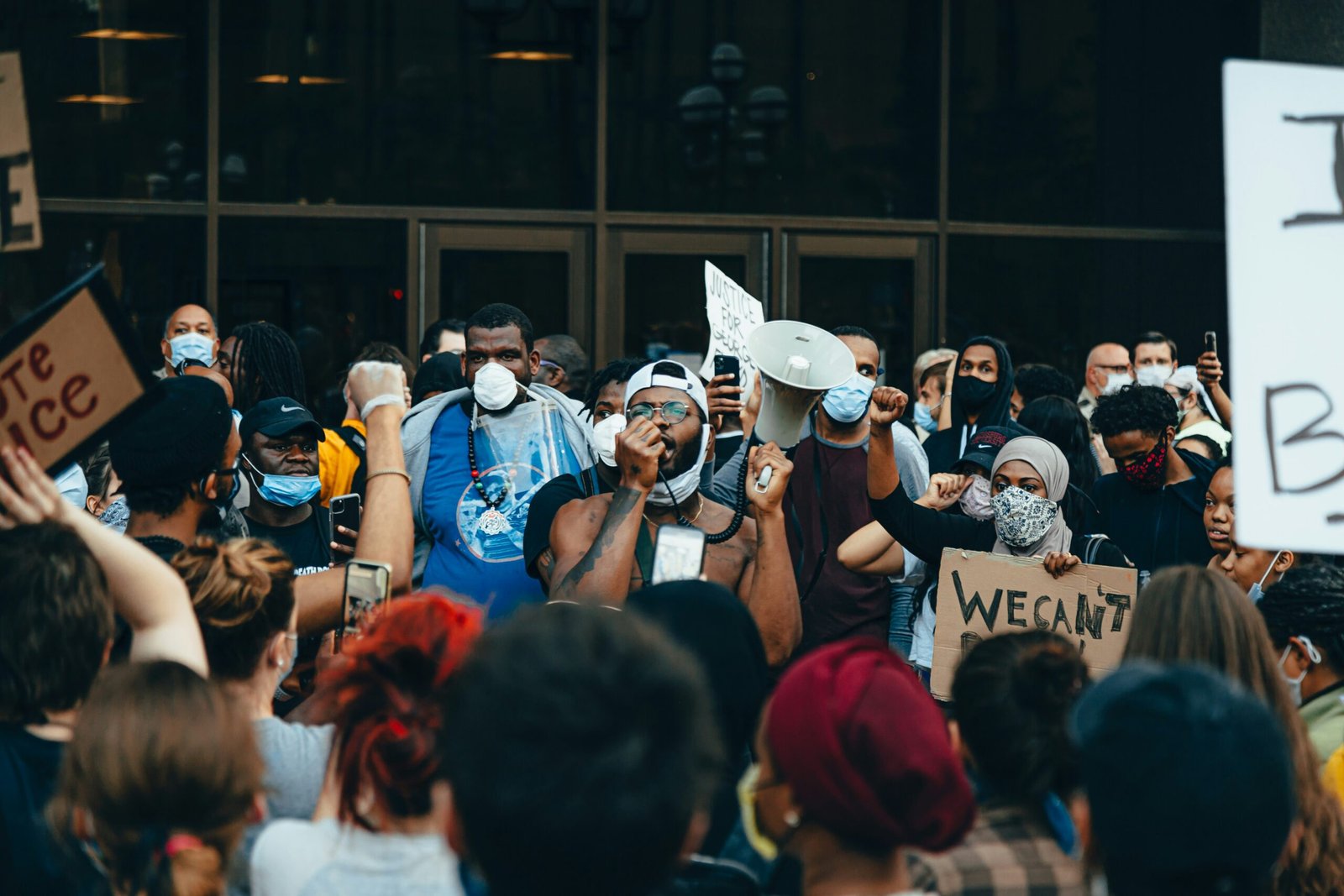 people in blue shirts and white hat standing on street during daytime