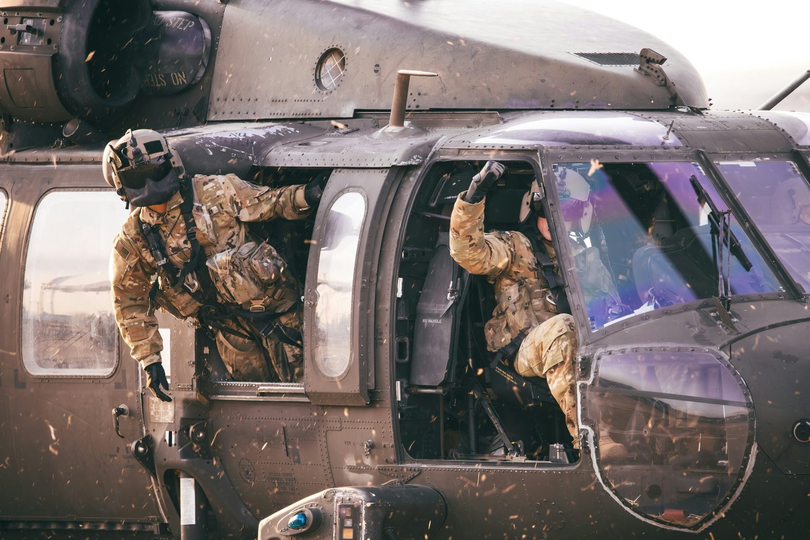 a couple of soldiers climbing out of a helicopter