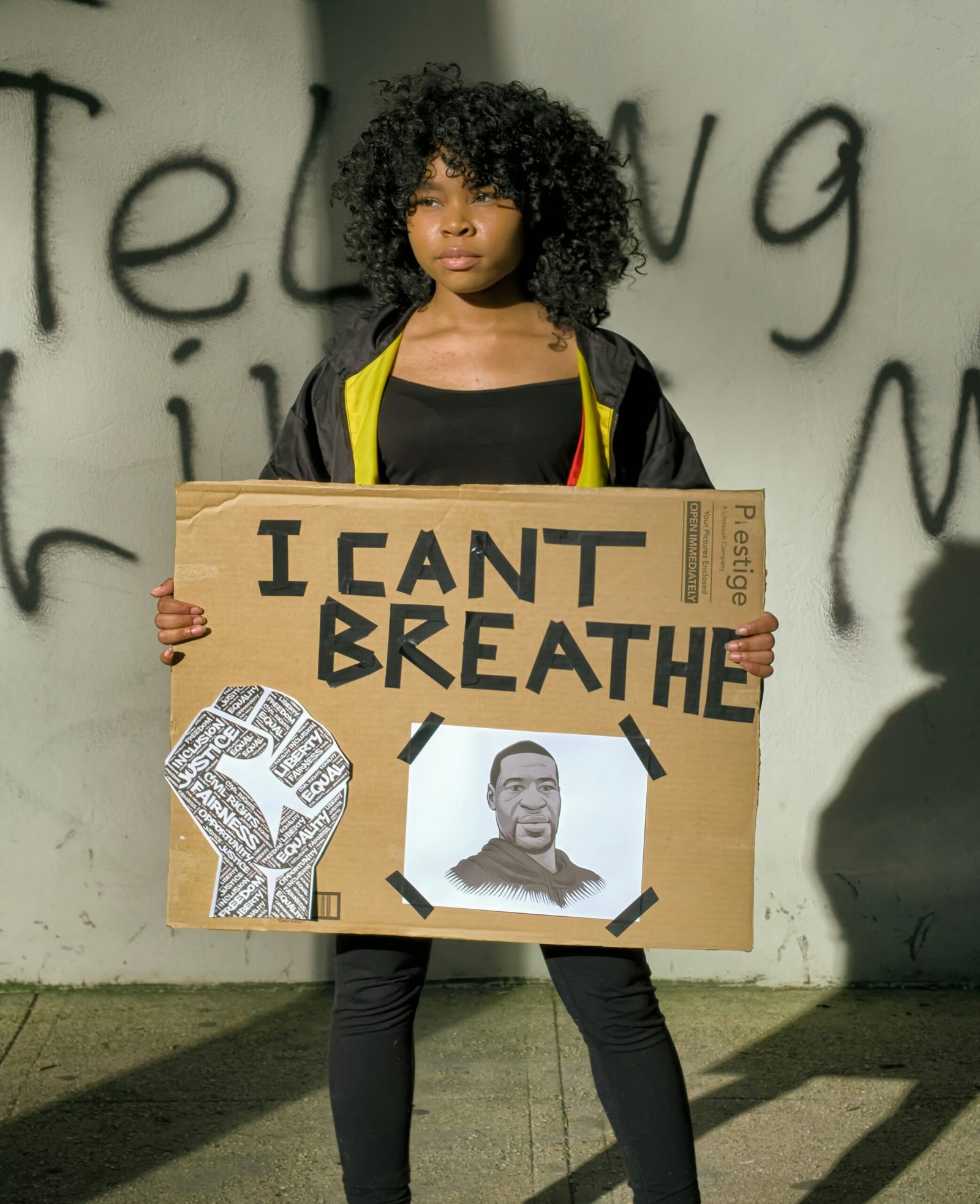 woman in black tank top and gray pants holding brown and white cardboard box